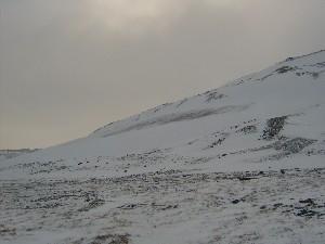 Ледник, припорошенный снегом, находящийся на северном склоне горы